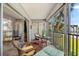 Relax on the tiled balcony with a table, chairs, and daybed overlooking the beautiful tropical landscape at 5600 Beach Way Dr # 201, Sarasota, FL 34242
