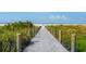 Picturesque beach access path with wooden posts leading to a pristine beach and sparkling blue waters at 5600 Beach Way Dr # 201, Sarasota, FL 34242
