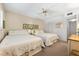 Bright bedroom featuring two twin beds with floral bedding, ceiling fan, and neutral wall color at 5600 Beach Way Dr # 201, Sarasota, FL 34242
