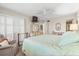 Bright bedroom featuring a bed, window with shutters, a sitting chair, and coordinated furniture at 5600 Beach Way Dr # 201, Sarasota, FL 34242