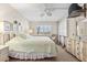 Relaxing bedroom featuring a bed, window with shutters, a ceiling fan, and a dresser with mirror at 5600 Beach Way Dr # 201, Sarasota, FL 34242