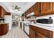 Galley kitchen featuring white appliances, tile floors, with a view of the dining and living area at 5600 Beach Way Dr # 201, Sarasota, FL 34242