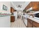 Galley kitchen featuring white appliances, tile floors, with a view of the dining and living area at 5600 Beach Way Dr # 201, Sarasota, FL 34242