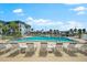 Community swimming pool surrounded by lounge chairs, umbrellas, and tropical landscaping at 5600 Beach Way Dr # 201, Sarasota, FL 34242