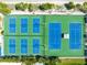Aerial view of well-maintained blue and green tennis courts surrounded by greenery at 5600 Beach Way Dr # 201, Sarasota, FL 34242