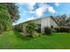 Well-manicured backyard with lush green grass, mature landscaping, and view of the house's exterior at 6024 28Th W St, Bradenton, FL 34207