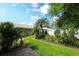 Landscaped front yard with green grass, mature plantings, and a view of the front exterior at 6024 28Th W St, Bradenton, FL 34207