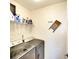 Functional laundry room with modern washer and dryer, shelving, and decorative vintage-style laundry embellishment at 6024 28Th W St, Bradenton, FL 34207