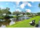 Peaceful pond featuring a fountain, lush green surroundings, and a comfortable bench at 6024 28Th W St, Bradenton, FL 34207