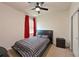 This bedroom features a black bed, black dresser, red curtains and a ceiling fan at 6204 Horse Mill Pl, Palmetto, FL 34221