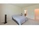 This carpeted bedroom features a gray comforter, and a vanity with a lighted mirror at 6204 Horse Mill Pl, Palmetto, FL 34221