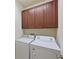 This laundry room features cabinets above a white washing machine and dryer at 6204 Horse Mill Pl, Palmetto, FL 34221