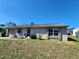 Single-story home with an attached garage, front door sitting area, and well-lit windows at 6405 Myrtlewood Rd, North Port, FL 34287