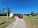 One-story home with an attached garage, long driveway, and nicely landscaped front yard featuring palms at 6405 Myrtlewood Rd, North Port, FL 34287