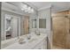 Well-lit bathroom featuring a large mirror, double sinks, and a glass-enclosed shower at 6515 Grand Estuary Trl # 208, Bradenton, FL 34212