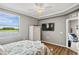Bright bedroom featuring a ceiling fan, dresser, and a serene outdoor view through a window at 6515 Grand Estuary Trl # 208, Bradenton, FL 34212