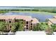 Multi-story condo building overlooking a pond and golf course, surrounded by palm trees at 6515 Grand Estuary Trl # 208, Bradenton, FL 34212
