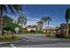 Beautifully landscaped clubhouse with palm trees, vibrant greenery and a welcoming entrance at 6515 Grand Estuary Trl # 208, Bradenton, FL 34212
