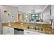 Open kitchen with granite countertops, stainless steel appliances, and views into the living area at 6515 Grand Estuary Trl # 208, Bradenton, FL 34212