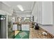 Modern kitchen with stainless appliances, granite counters, and a view into the living area at 6515 Grand Estuary Trl # 208, Bradenton, FL 34212