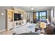 Comfortable living room with large TV, nautical decor, and a view of the lanai and pond at 6515 Grand Estuary Trl # 208, Bradenton, FL 34212
