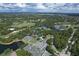 Wide aerial view of community featuring lakes, tennis courts, trees, and lush landscaping at 7214 Marlow Pl, University Park, FL 34201