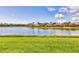 Serene backyard view with lush green grass extending to a tranquil lake at 7214 Marlow Pl, University Park, FL 34201