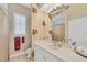 Bathroom featuring a large mirror, floral wallpaper, and an elegant countertop with fixtures at 7214 Marlow Pl, University Park, FL 34201