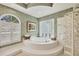 Elegant bathroom features soaking tub, glass block, and stylish wallpaper with a garden window at 7214 Marlow Pl, University Park, FL 34201