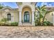 Close-up of an elegant entryway with white columns, an arched doorway, and a charming green front door at 7214 Marlow Pl, University Park, FL 34201