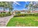 Attractive single-story home with manicured lawn, paved driveway, and lush tropical landscaping around the property at 7214 Marlow Pl, University Park, FL 34201