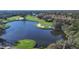 Picturesque aerial view of golf course alongside a serene lake and lush greenery at 7214 Marlow Pl, University Park, FL 34201