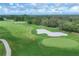 Scenic aerial view of golf course with sand traps and pristine green grass at 7214 Marlow Pl, University Park, FL 34201