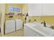 Convenient laundry room with washer, dryer, utility sink, and ample storage, enhancing functionality at 7214 Marlow Pl, University Park, FL 34201