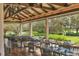 Covered patio dining area overlooking lush landscape, a lake, and the golf course at 7214 Marlow Pl, University Park, FL 34201
