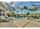 Screened-in pool with tropical landscaping and lake views perfect for relaxation and entertaining guests at 7214 Marlow Pl, University Park, FL 34201