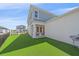 Charming backyard features manicured lawn, covered patio with outside seating, and a white fence for privacy at 7279 Kodiak Ln, Sarasota, FL 34240