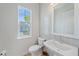 Bathroom featuring white tiled walls, toilet, sink, mirror, and window with outdoor view at 7279 Kodiak Ln, Sarasota, FL 34240