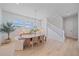 Dining room with light wood flooring, modern chandelier, and view of staircase and windows at 7279 Kodiak Ln, Sarasota, FL 34240