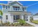 Charming two-story home with light blue siding, a welcoming front porch, and landscaped front yard at 7279 Kodiak Ln, Sarasota, FL 34240