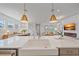 Modern kitchen with stainless steel appliances, white farmhouse sink, pendant lighting, and open floor plan at 7279 Kodiak Ln, Sarasota, FL 34240