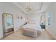 Bright main bedroom showcasing a decorative mirror, contemporary lighting, and a padded bench at 7279 Kodiak Ln, Sarasota, FL 34240