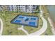 Overhead view of pickleball courts in a fenced area by the water with manicured lawns and sidewalk at 7279 Kodiak Ln, Sarasota, FL 34240