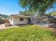 Large backyard with lawn, brick walkway, pool with lanai, and mature trees offering ample shade at 7460 Dickens Dr, Sarasota, FL 34231