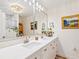 A bright bathroom with double sinks, decorative mirrors, updated lighting, and modern fixtures at 7460 Dickens Dr, Sarasota, FL 34231