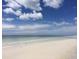Expansive beach featuring pristine white sands meeting the tranquil turquoise waters under a bright sky with fluffy white clouds at 7460 Dickens Dr, Sarasota, FL 34231