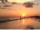 Picturesque beach at sunset with people enjoying the cool ocean air as the sun sets and reflects on the water at 7460 Dickens Dr, Sarasota, FL 34231