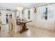 Elegant dining room featuring a large wooden table, decorative chandelier, and sheer white curtains at 7460 Dickens Dr, Sarasota, FL 34231
