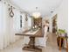 Charming dining room with a large wooden table, delicate chandelier, and sheer curtains, perfect for entertaining guests at 7460 Dickens Dr, Sarasota, FL 34231