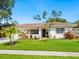 Inviting home with a well-manicured lawn, flowering plants and charming curb appeal at 7460 Dickens Dr, Sarasota, FL 34231